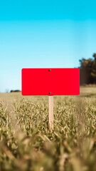 blank red sign stands a field green grass