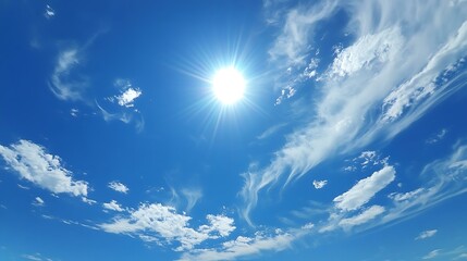 a clear, bright blue sky with the sun shining and only a few wispy clouds scattered around