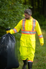 Volunteer man collecting trash outside. Ecology concept. Environmental pollution. Earth Day. Recycle waste litter rubbish garbage trash junk clean. Nature cleaning. Environment plastic pollution.