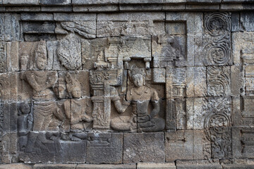 Wall with old religious stone statues in Borobudur Temple in Indonesia