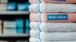 © Nitchalee N. - Soft towels stacked neatly, labeled 'best value,' showcasing a retail setting with a focus on quality and affordability.