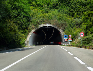 Interior view of a highway tunnel with cars, capturing modern infrastructure and urban transportation in motion