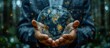 © MBRAMO - Person holding a glowing Earth globe in their hands.