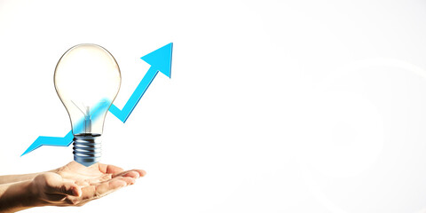 Wall Mural - lightbulb in human hand with upward blue arrow symbolizing growth on white background. concept of id