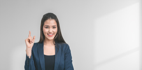 woman in a suit smiling and gesturing with her finger in a brigh