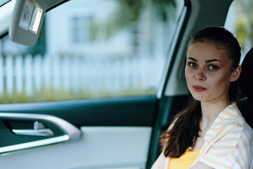 Canvas Print - portrait of a young woman sitting in a car, looking thoughtful Natural background, soft colors highlighting her calm expression Ideal for lifestyle or transport themes