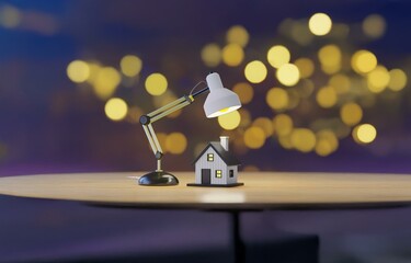 A desk lamp illuminates a small house model, with bokeh lights in the background.