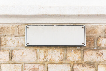 Wall Mural - Rustic street name sign on a brick wall. Dirty, grunge texture with empty copy space. Blank area for text on an old wall. Vintage architecture. Metal frame street name. Address plate background.