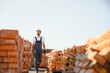 © Serhii - Construction worker man in work clothes and a construction helmet. Portrait of positive male builder in hardhat working at construction site