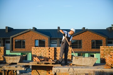 Installing brick wall. Construction worker in uniform and safety equipment have job on building