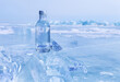 © Katvic - Glass bottle with cold natural drinking water stands on ice of frozen Baikal Lake on cold winter day. Advertising and branding of fresh ecological water. Nature ice background. Copy space, mock up