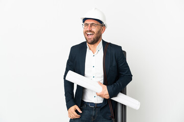 Architect man with helmet and holding blueprints isolated on white background laughing