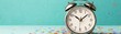 © Preeyanuch - A classic silver alarm clock against a vibrant teal background, perfect for portraying time management and celebration.