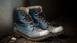 © dropideas - A pair of blue work boots covered in mud and dirt.