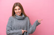 © luismolinero - Young caucasian woman isolated on pink bakcground pointing finger to the side