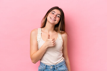 Wall Mural - Young caucasian woman isolated on pink background giving a thumbs up gesture