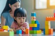 © useful pictures - A Vietnamese mother and her daughter playing together with colorful building blocks in a sunlit room during a playful afternoon