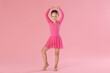 © New Africa - Little ballerina practicing dance moves on pink background