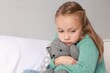 © New Africa - Autism concept. Lonely little girl with toy bunny on bed at home, space for text