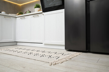 Canvas Print - Stylish soft rug on wooden floor in kitchen