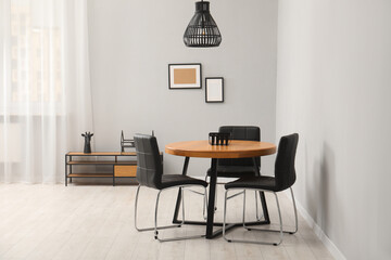 Wall Mural - Wooden table with black chairs in stylish dining room