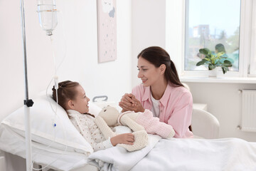 Wall Mural - Mother and her little daughter on bed in hospital