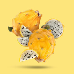 Wall Mural - Yummy pitaya fruits falling on yellow background