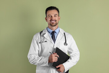 Canvas Print - Smiling doctor with stethoscope and clipboard on olive background