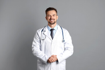 Canvas Print - Smiling doctor with stethoscope on grey background