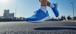 © ViktoGraphics - A close-up of the feet and shoes running on an asphalt road.