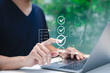 © Supatman - Online assessment and survey concept. A person interacts with virtual checklist on laptop, symbolizing online assessments, surveys, exams, or quizzes. digital evaluation and data collection. fill out,