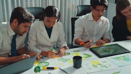 Professional engineer team in casual cloth talking about turbine engine structure at table with metal gear, calculator, sticky notes. Group of technician standing and attend in meeting. Alimentation.