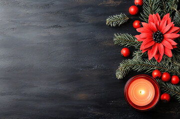 Christmas decoration with lit red candle, red poinsettia and pine branches lying on empty dark textured table