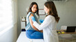 © AntonioDiaz - Professional medical worker wearing gloves is vaccinating a young woman in a doctor's office