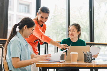 Wall Mural - Collaborative women working together in modern office space, sharing ideas and documents while enjoying coffee. Their expressions reflect enthusiasm and teamwork