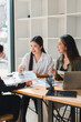 © PRIME STOCK LAB - Collaborative business meeting with three women discussing project details, sharing ideas, and reviewing documents in modern office setting. Their expressions reflect engagement and teamwork