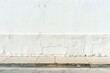 © KerXing - Close-up of a textured white wall with visible cracks above a concrete sidewalk, capturing urban simplicity and minimalism.