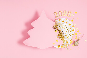 Wall Mural - Celebrating coming year 2025. Paper cut Christmas tree mockup for text and greetings. Bright plates with stars, glasses, straws, decorations, candles, confetti on pastel pink background. Flat lay