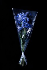 Wall Mural - A bouquet of blue flowers wrapped in clear plastic against a black background.