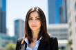 © Minerva Studio - Confident businesswoman smiling with city skyline in background