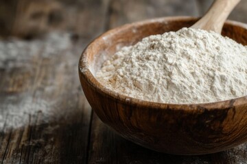 Wall Mural - Wooden spoon resting in a bowl of white flour on rustic wooden table