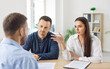 © Studio Romantic - Family couple engages in a briefing and conversation with a real estate consultant or insurance agent in the office. They discuss important aspects of the contract and finalize the deal.