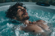 © Babb - A man is in a hot tub, relaxing and enjoying the warm water