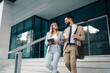 © Zamrznuti tonovi - Business people walking down stairs outside office building holding coffee and tablet having a discussion