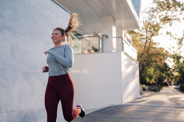 Young woman running and smiling on a sunny day