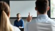 © Aris Suwanmalee - A professional meeting scene showing an engaged audience member raising a hand to ask a question during a presentation.