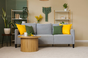 Interior of stylish living room with grey sofa, colorful cushions and coffee table