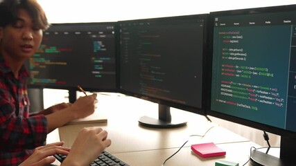 Slow motion back end software developer engineer for computer programming working together on debugging writing computing code, solving complex algorithms display on monitor in office. Burgeoning