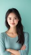 © Todd's Studio - an Asian woman in her mid-20s, standing with her arms crossed, looking at the camera with a slight smile. The background is a solid pastel color
