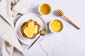 Wall Mural - Morning sandwiches on grain bread with honey butter on a plate on the table top view